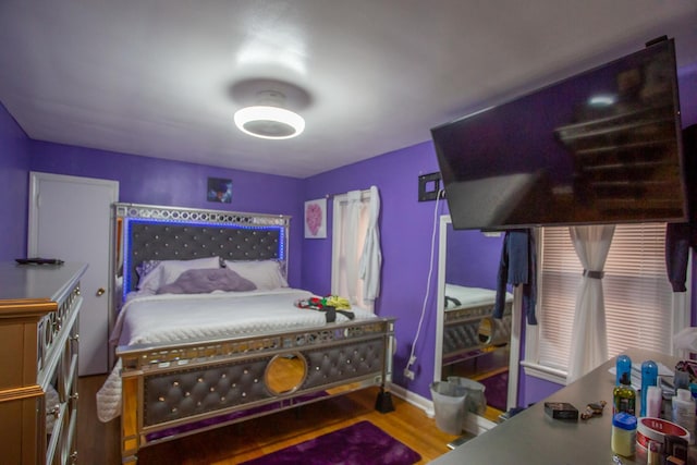bedroom featuring baseboards and wood finished floors
