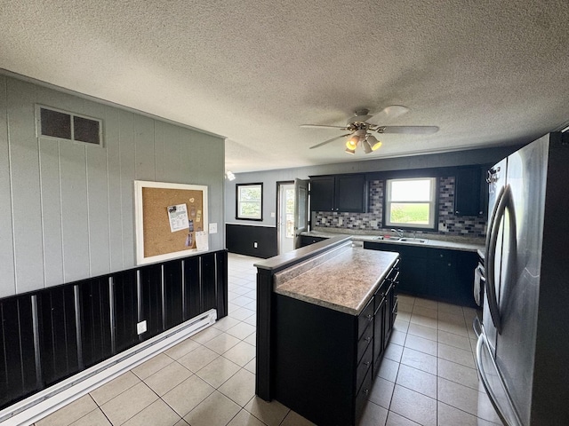 26812 US-150 Hwy, Leroy, IL 61752 - kitchen with freestanding refrigerator, dark cabinetry, light countertops, healthy amount of natural light, and a textured ceiling