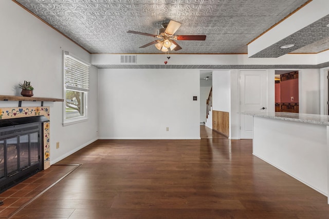 unfurnished living room with an ornate ceiling, wood finished floors, ceiling fan, a fireplace, and visible vents