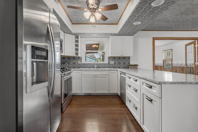 kitchen featuring a peninsula, a wealth of natural light, stainless steel appliances, and a sink