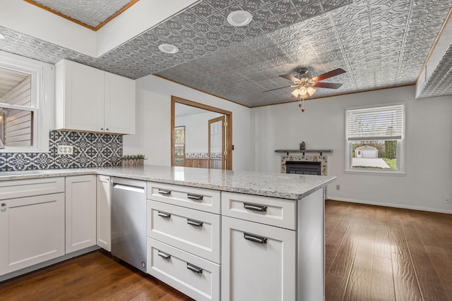 kitchen with dark wood finished floors, dishwasher, an ornate ceiling, a peninsula, and ceiling fan