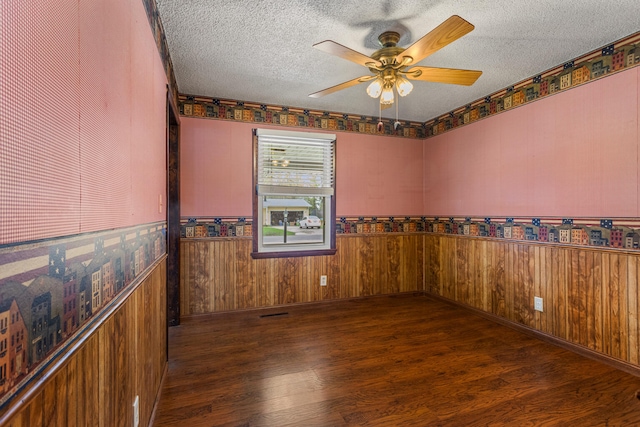 spare room with wood finished floors, a textured ceiling, and ceiling fan