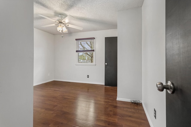 spare room featuring ceiling fan, baseboards, wood finished floors, and a textured ceiling