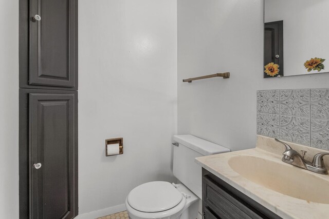 half bathroom with vanity and toilet