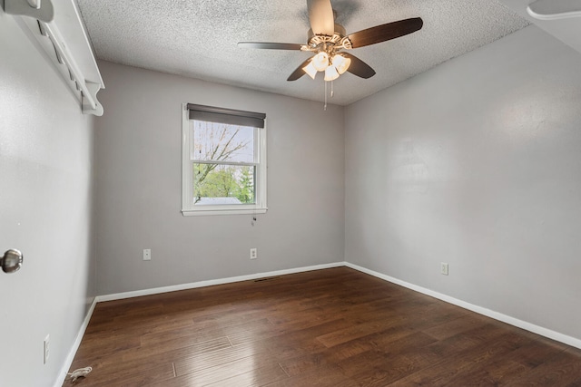 spare room featuring baseboards, a ceiling fan, wood finished floors, and a textured ceiling
