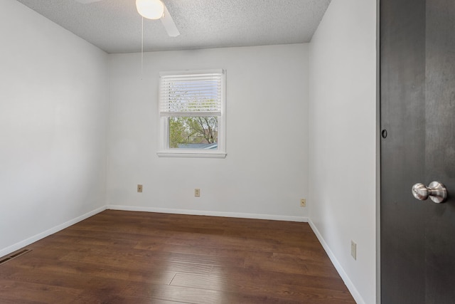 empty room with a textured ceiling, visible vents, baseboards, wood finished floors, and ceiling fan