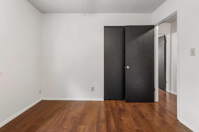 empty room with baseboards and wood finished floors