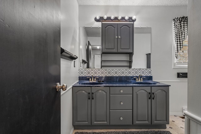 full bathroom featuring tasteful backsplash, a textured ceiling, and a sink