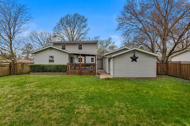 back of property with a fenced backyard, an outbuilding, a chimney, and a yard