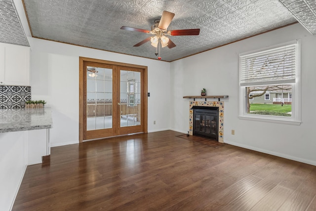 unfurnished living room with french doors, wood finished floors, a wealth of natural light, and crown molding