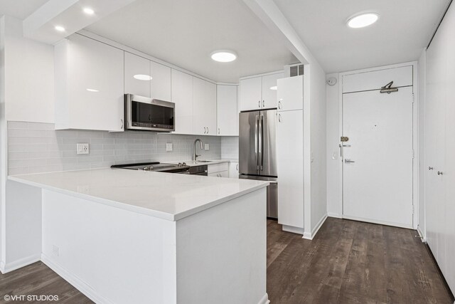 1560 N Sandburg Ter Unit 3207J, Chicago, IL 60610 - kitchen featuring visible vents, stainless steel appliances, light countertops, dark wood-style flooring, and a peninsula