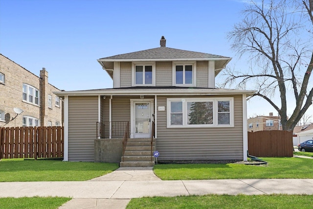 american foursquare style home featuring a porch, fence, a front yard, and a chimney