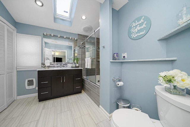 full bathroom featuring a closet, vanity, toilet, tiled shower / bath combo, and a skylight