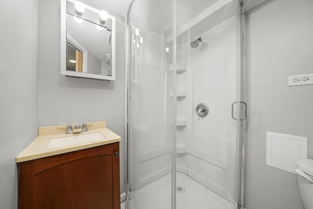 full bathroom with vanity, toilet, and a shower stall