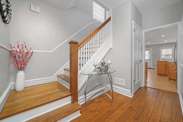 staircase featuring visible vents, recessed lighting, baseboards, and wood finished floors