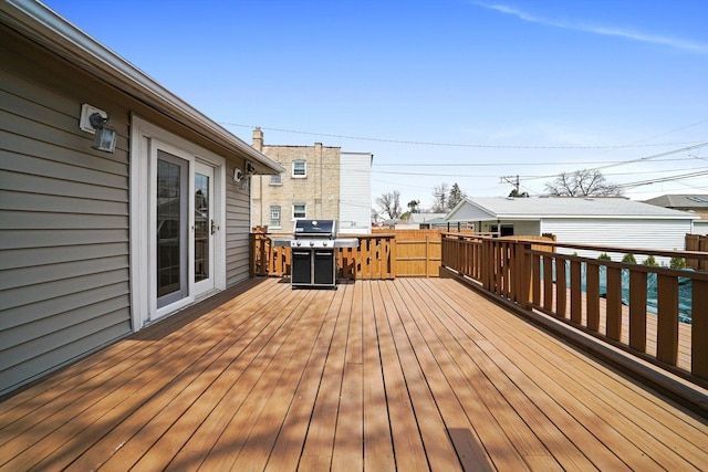 wooden deck with fence and area for grilling