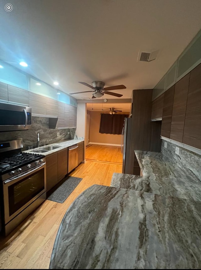 3105 172nd St, Hazel Crest, IL 60429 - kitchen featuring appliances with stainless steel finishes, light wood finished floors, modern cabinets, and tasteful backsplash