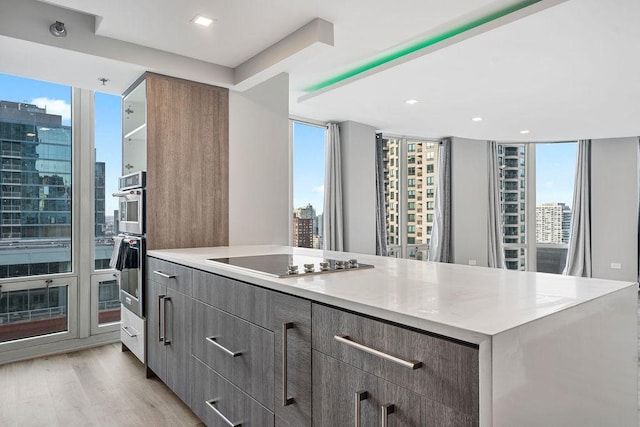 345 N La Salle Dr Unit 2501, Chicago, IL 60654 - kitchen with black electric cooktop, light countertops, modern cabinets, and a view of city