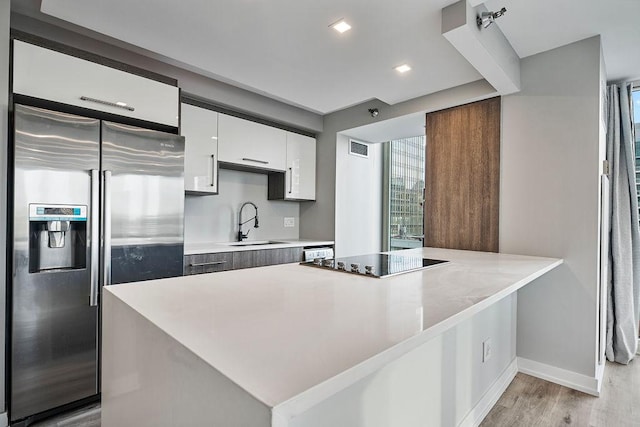 345 N La Salle Dr Unit 2501, Chicago, IL 60654 - kitchen with black electric cooktop, visible vents, a sink, a peninsula, and stainless steel refrigerator with ice dispenser
