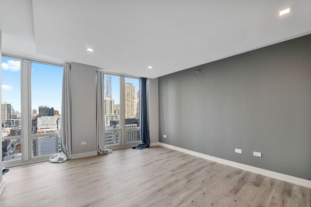 345 N La Salle Dr Unit 2501, Chicago, IL 60654 - unfurnished room featuring recessed lighting, baseboards, a city view, and light wood-style flooring
