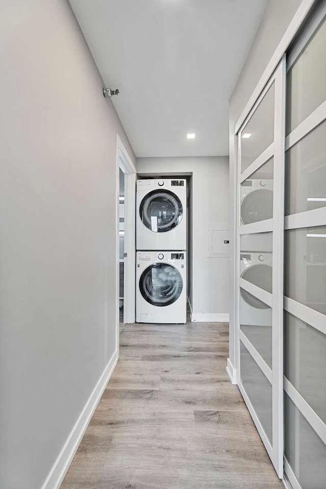 345 N La Salle Dr Unit 2501, Chicago, IL 60654 - laundry room with stacked washer and dryer, baseboards, wood finished floors, and laundry area