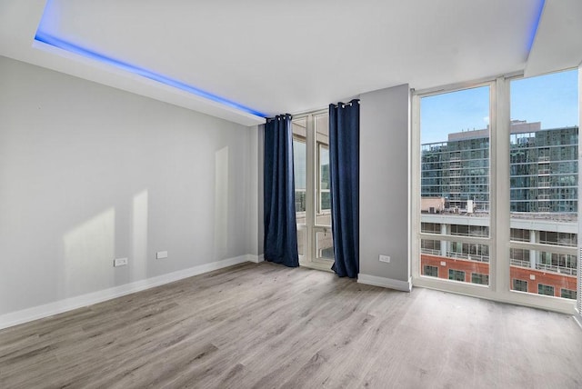 345 N La Salle Dr Unit 2501, Chicago, IL 60654 - empty room featuring a city view, baseboards, expansive windows, and wood finished floors