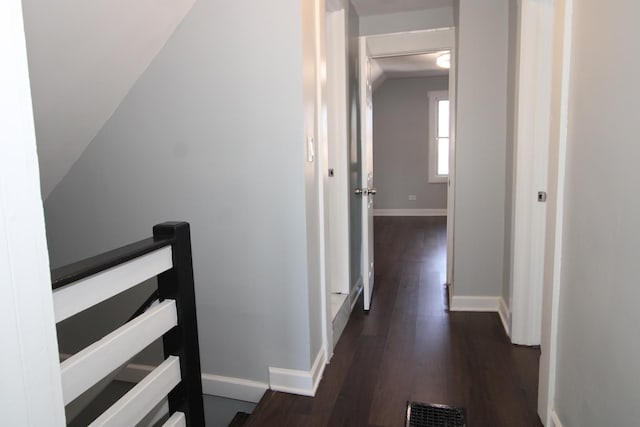 hall featuring baseboards, dark wood-style floors, an upstairs landing, and lofted ceiling