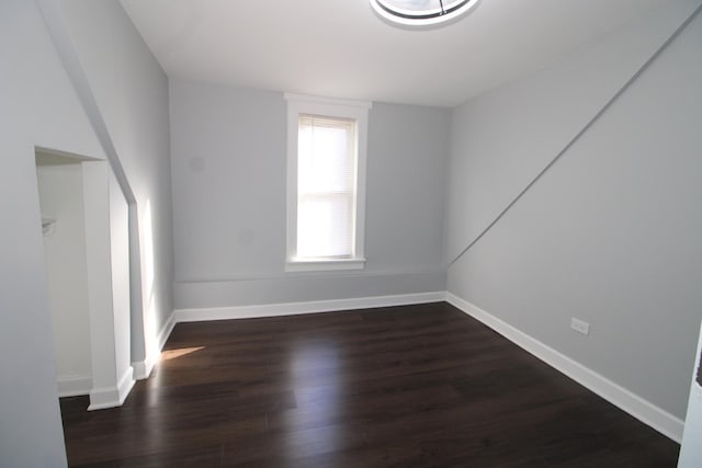spare room featuring wood finished floors and baseboards