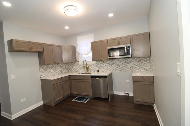 kitchen with stainless steel appliances, a sink, dark wood-style flooring, tasteful backsplash, and recessed lighting