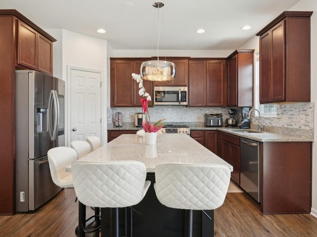 412 Towne Center Blvd, Shorewood, IL 60404 - kitchen featuring a center island, a sink, stainless steel appliances, dark wood-type flooring, and tasteful backsplash