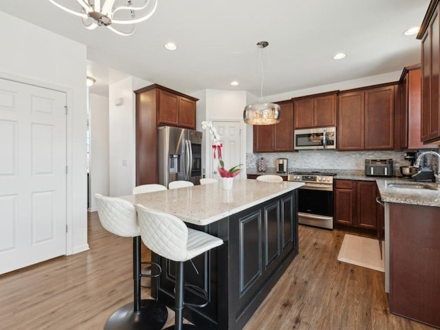 412 Towne Center Blvd, Shorewood, IL 60404 - kitchen featuring a sink, dark wood-style flooring, a kitchen island, and appliances with stainless steel finishes