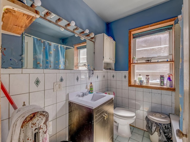 2936 N Kilpatrick Ave, Chicago, IL 60641 - bathroom featuring tile patterned floors, toilet, vanity, a shower with curtain, and tile walls
