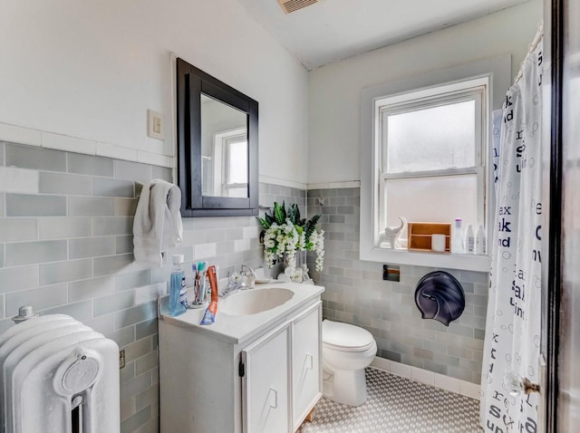 2936 N Kilpatrick Ave, Chicago, IL 60641 - bathroom featuring tile walls, vanity, a wealth of natural light, and toilet