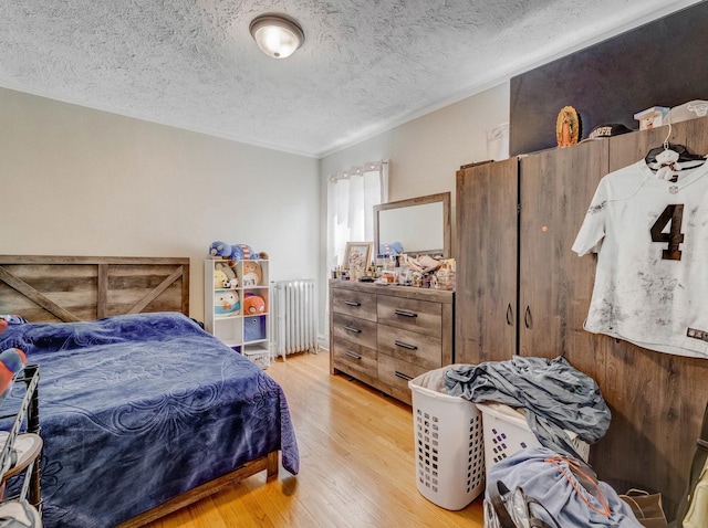 2936 N Kilpatrick Ave, Chicago, IL 60641 - bedroom with wood finished floors, a textured ceiling, ornamental molding, and radiator