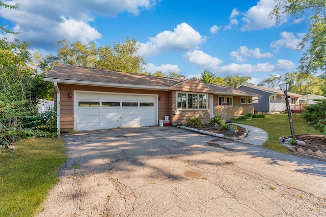 ranch-style house featuring a garage and driveway