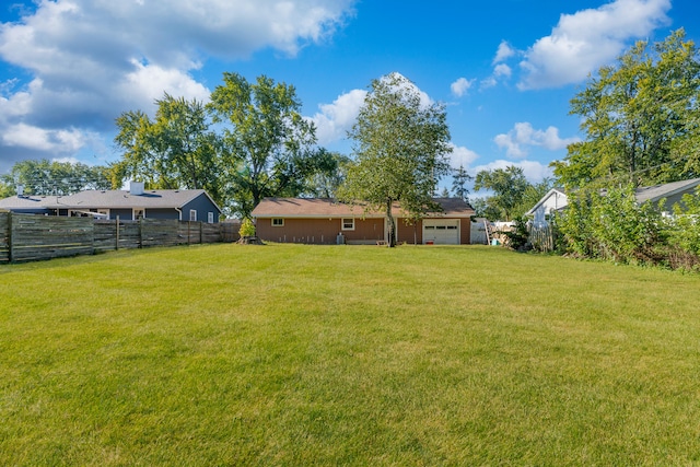 view of yard featuring fence and a garage