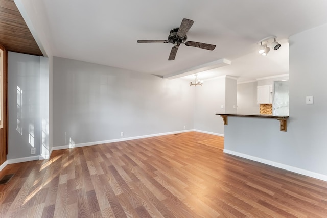 unfurnished living room with baseboards, light wood-style floors, visible vents, and ceiling fan with notable chandelier