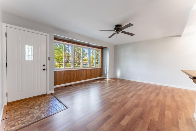foyer entrance featuring visible vents, a ceiling fan, baseboards, and light wood-type flooring