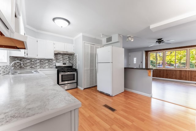kitchen featuring a sink, visible vents, freestanding refrigerator, white cabinetry, and stainless steel gas stove