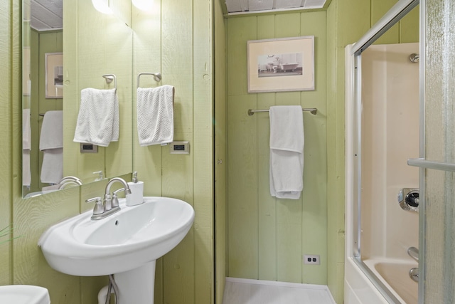 full bath featuring combined bath / shower with glass door and a sink