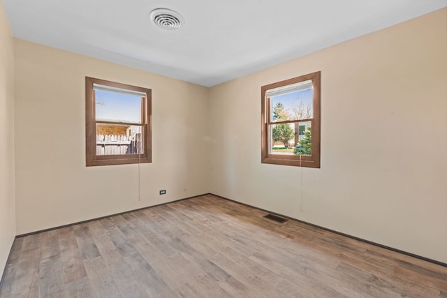 empty room featuring wood finished floors and visible vents