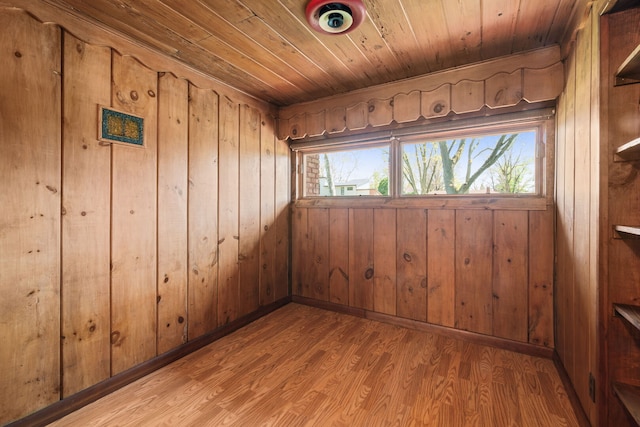 empty room with wooden ceiling, wood walls, and wood finished floors