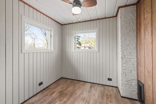 spare room featuring ceiling fan, wood finished floors, and visible vents