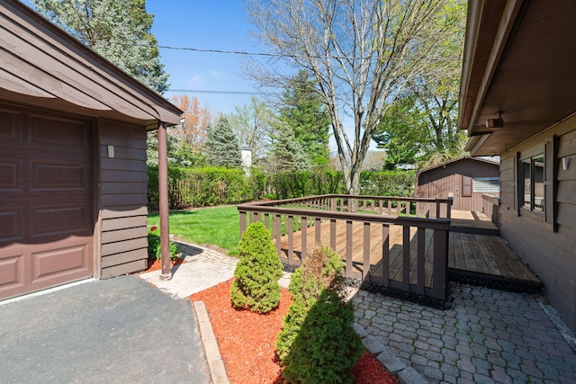 view of yard featuring a deck, an outbuilding, and a garage