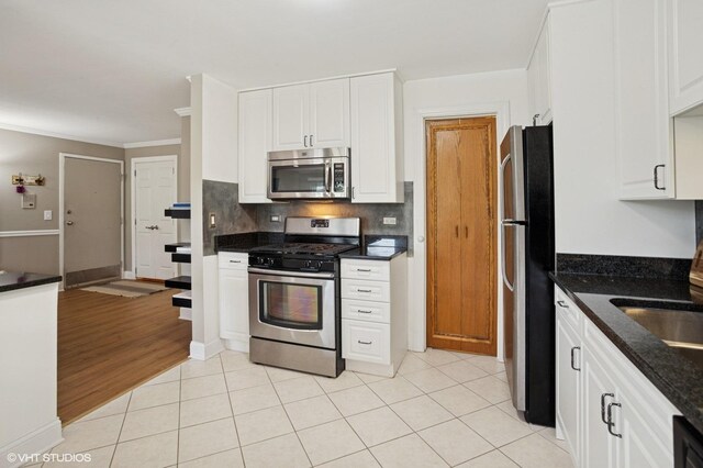 941 Yosemite Trl Unit C7, Roselle, IL 60172 - kitchen with stainless steel appliances, white cabinets, decorative backsplash, light tile patterned floors, and a sink