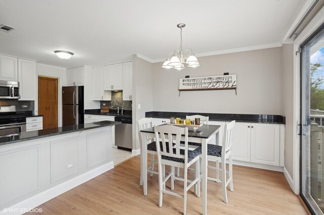 941 Yosemite Trl Unit C7, Roselle, IL 60172 - kitchen featuring appliances with stainless steel finishes, a chandelier, tasteful backsplash, a sink, and white cabinets