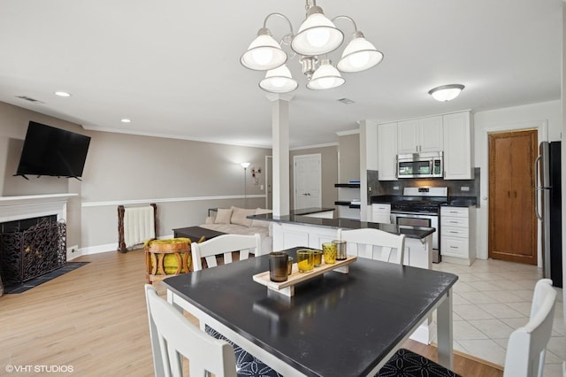 941 Yosemite Trl Unit C7, Roselle, IL 60172 - dining area with a chandelier, a high end fireplace, baseboards, recessed lighting, and light wood-type flooring