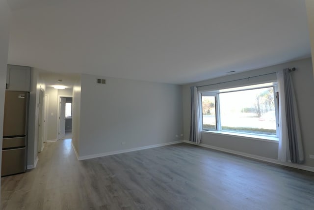 1503 N Milwaukee Ave Unit 2B, Libertyville, IL 60048 - unfurnished room featuring light wood-type flooring, visible vents, baseboards, and plenty of natural light