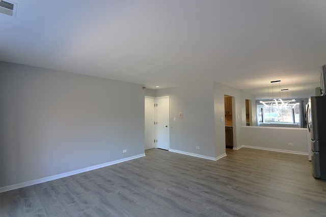 1503 N Milwaukee Ave Unit 2B, Libertyville, IL 60048 - spare room featuring baseboards, wood finished floors, visible vents, and a chandelier