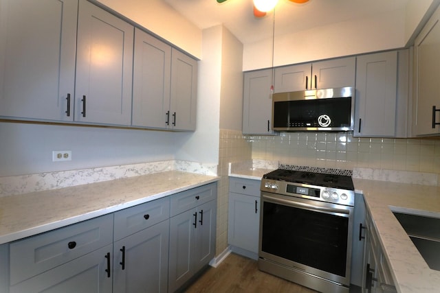 1503 N Milwaukee Ave Unit 2B, Libertyville, IL 60048 - kitchen featuring stainless steel appliances, gray cabinetry, backsplash, and dark wood-style flooring